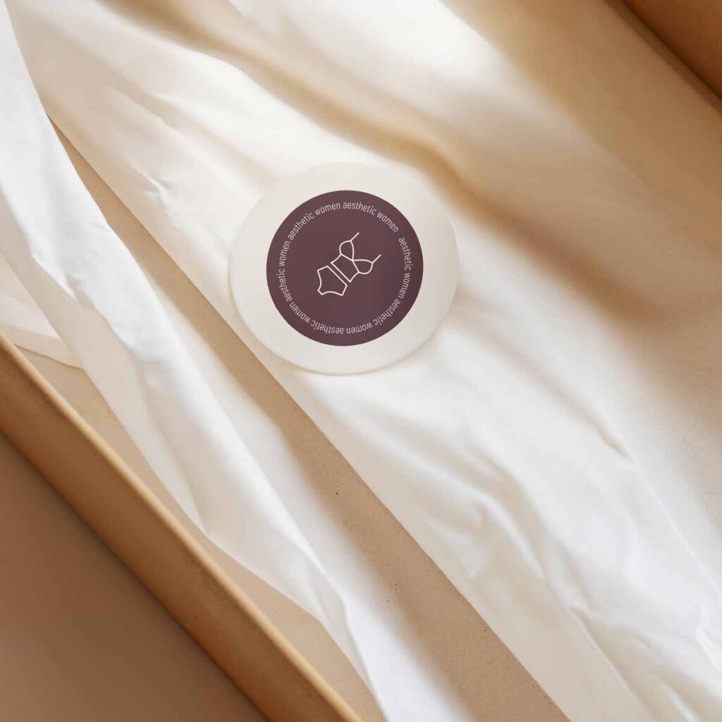 Verpackungsdesign für ein Wäschegeschäft mit gebrandetem Aufkleber auf Seidenpapier als Teil eines ganzheitlichen Marken- und Raumkonzepts.